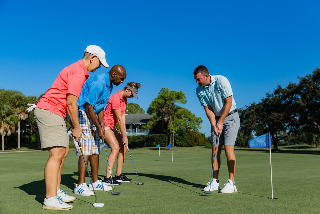 Golf instructor teaching a lesson on the putting green